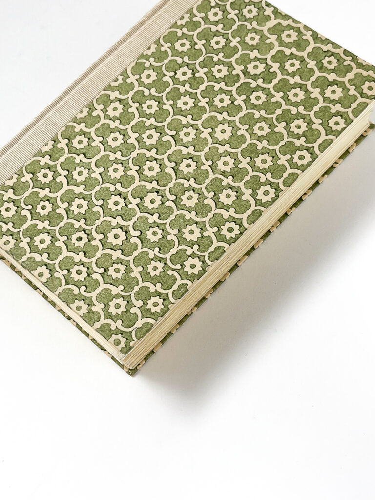 Binding image showing a green book with white flower details