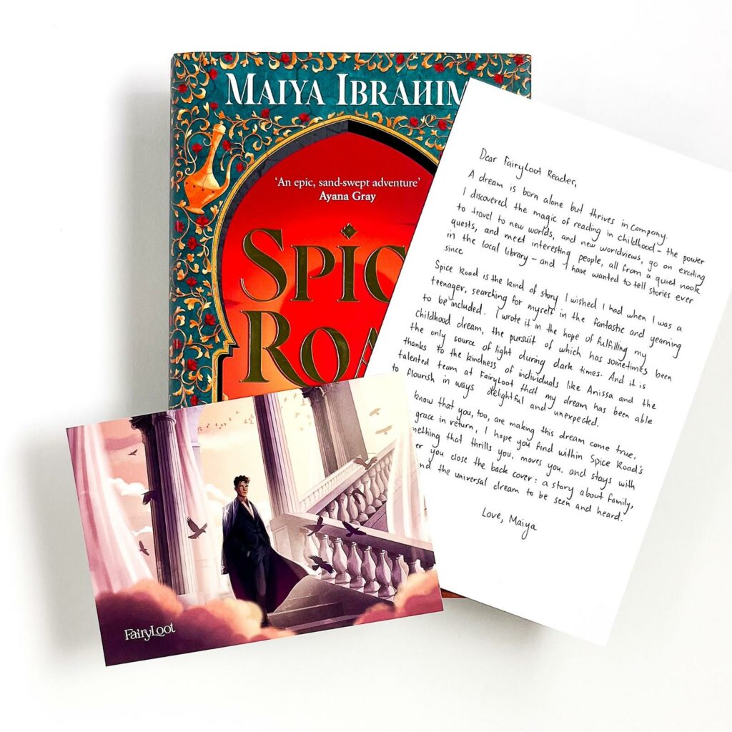 FairyLoot issue of Spice Road by Maiya Ibrahim (2023), on top of which are two pieces of FairyLoot ephemera: one a printed copy of a letter from the author beginning “Dear FairyLoot Reader” and the other an illustrated postcard.