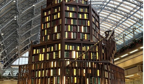 A "book tree" made up of book shelves in the shape of a tree, with a nook underneath for people to sit.
