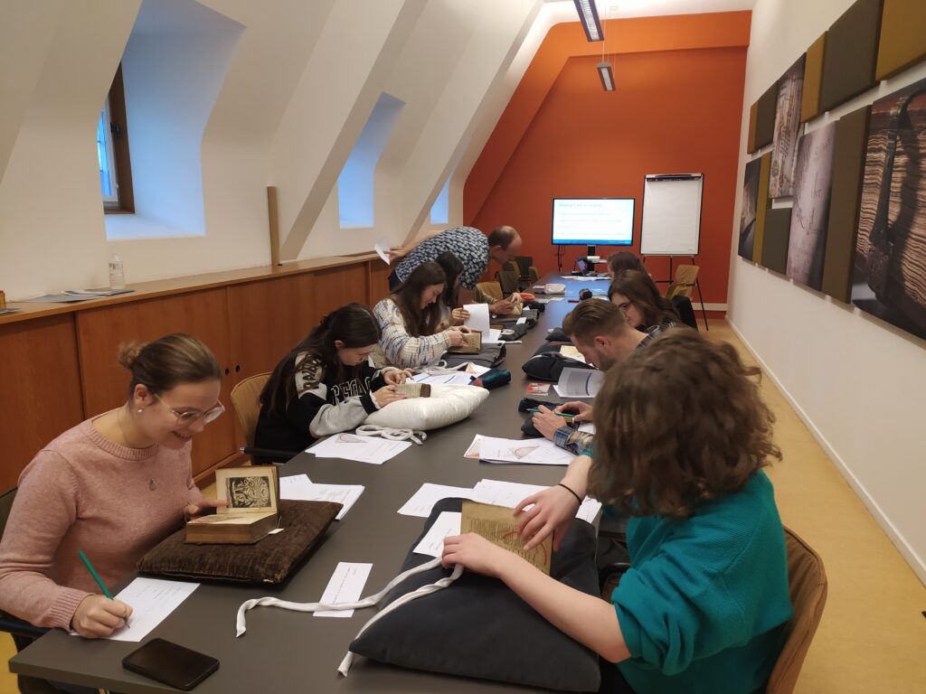 Students seated at a table work with rare books.