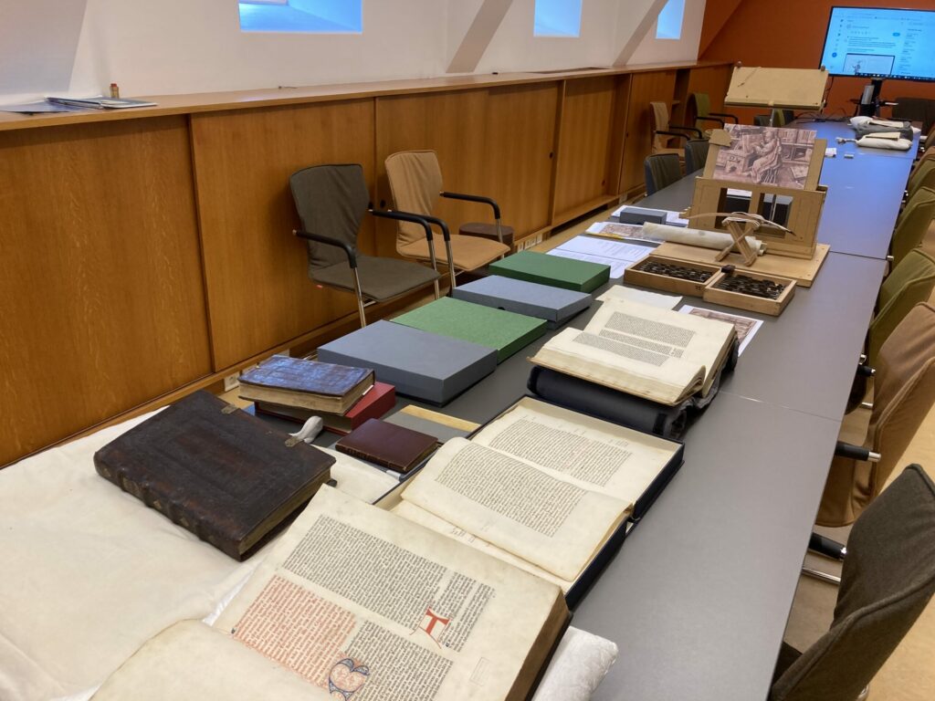 Open books and other objects laid out on  table.