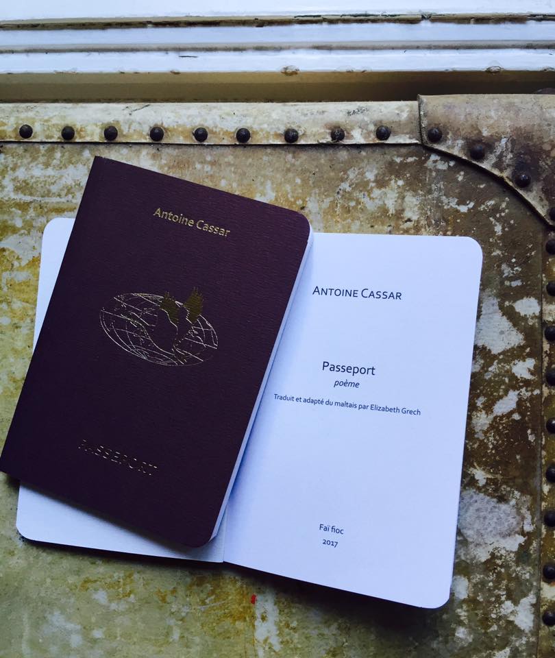 photograph of two copies of the French edition of “Passeport” by Antoine Cassar. A closed copy lies atop an opened one. The cover is dark brown with gold embossed title and author’s name and an image of a goose flying around the terrestrial globe. Underneath, the opened copy shows the imprint page.