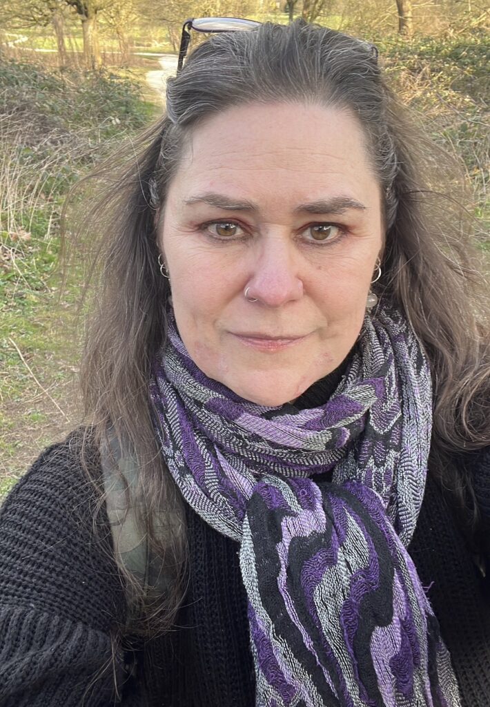 Headshot of Jocelyn Hargrave, who is wearing a dark sweater with a purple scarf.